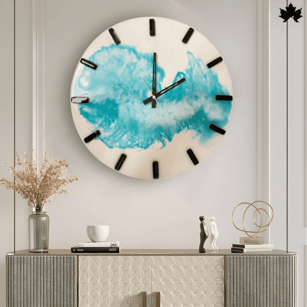 The Azure Wave - Modern Wall Clock features an artistic splash of blue resin on a clean white background, accentuated by minimalist black clock hands and bold numerals. This clock effortlessly combines functional timekeeping with contemporary wall art, making it a striking addition to any modern living space.
